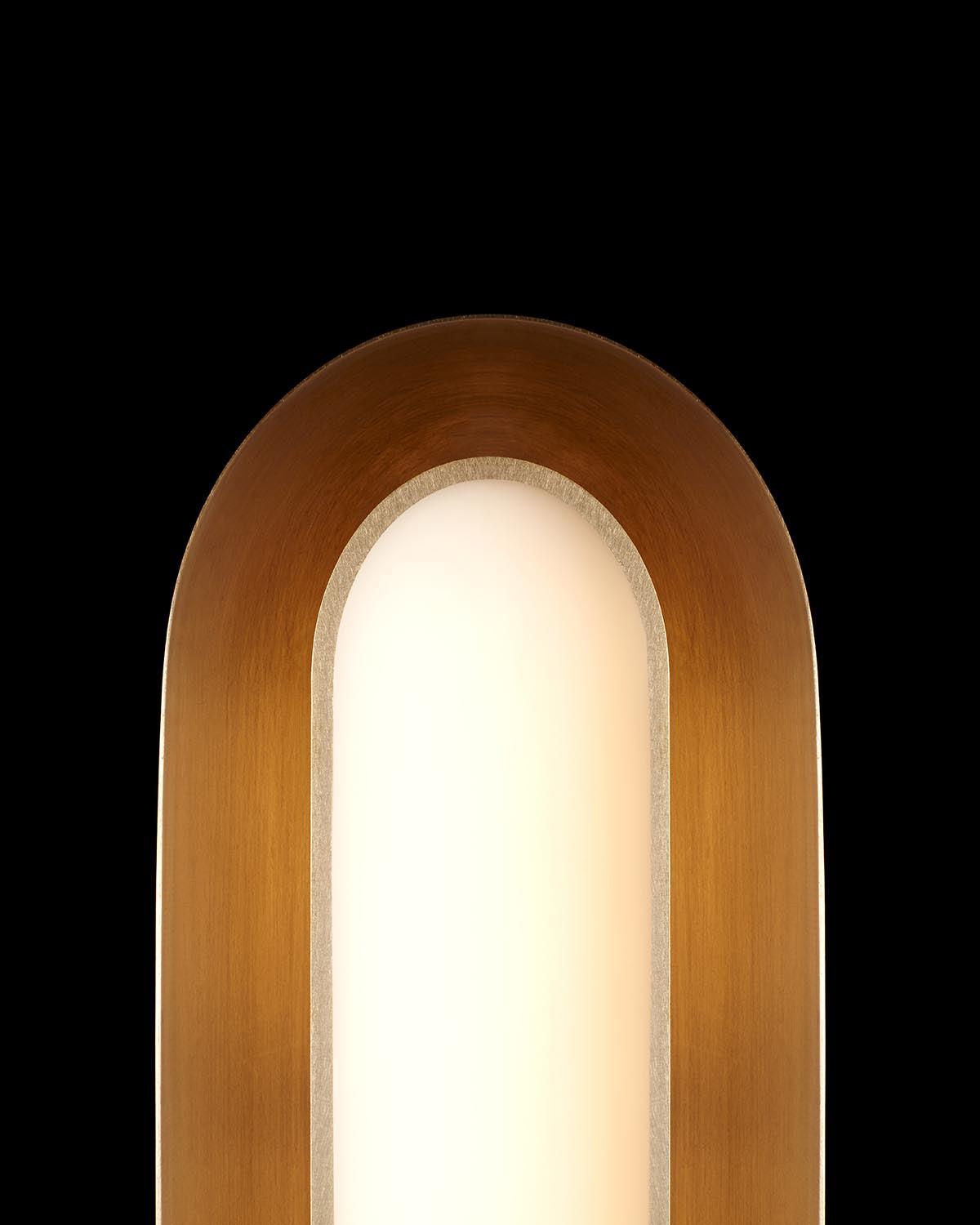 Close-up of minimalist vertical wall light with warm brown curved frame and soft white illuminated center on black background