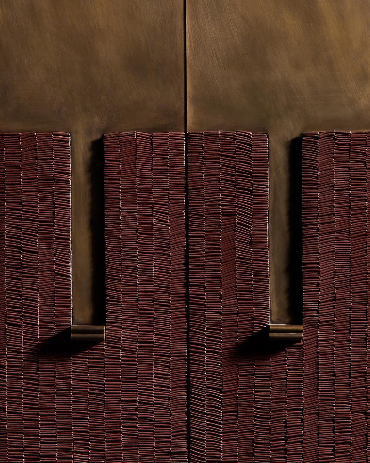 Close-up of textured dark brown cabinet doors with vertical ridged pattern and smooth recessed handles against warm background