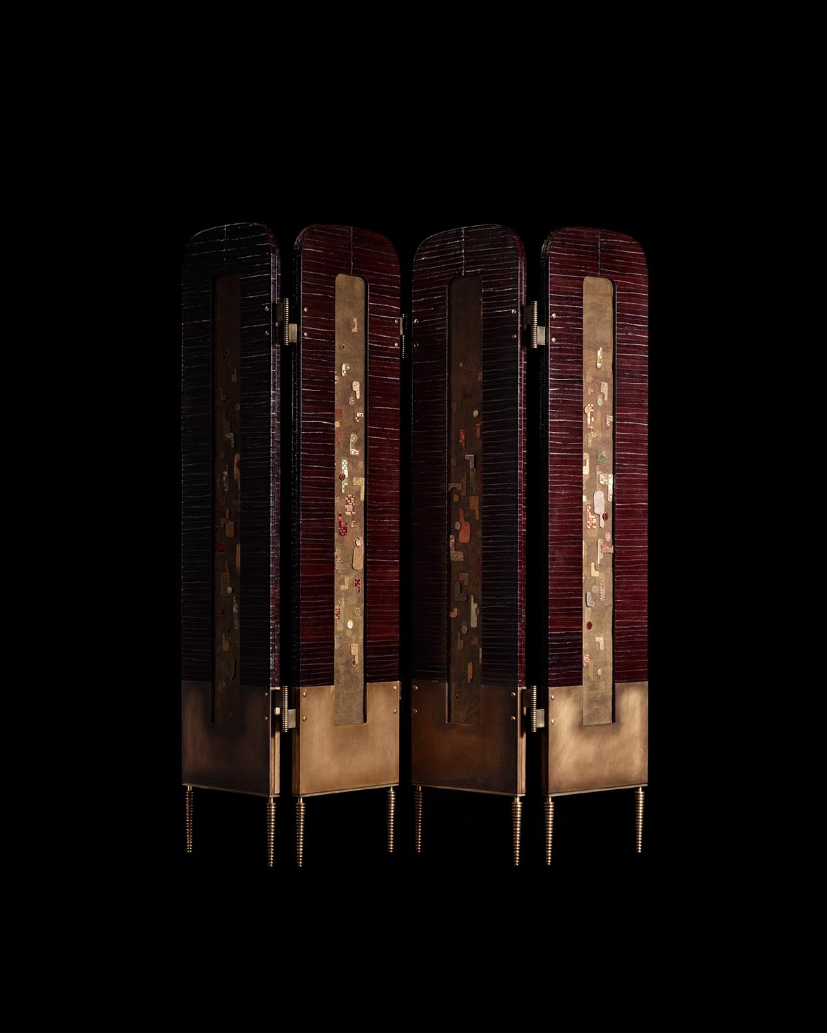 Four-panel hand-embroidered screen with deep red fabric panels, brass accents, and slender legs on a black background