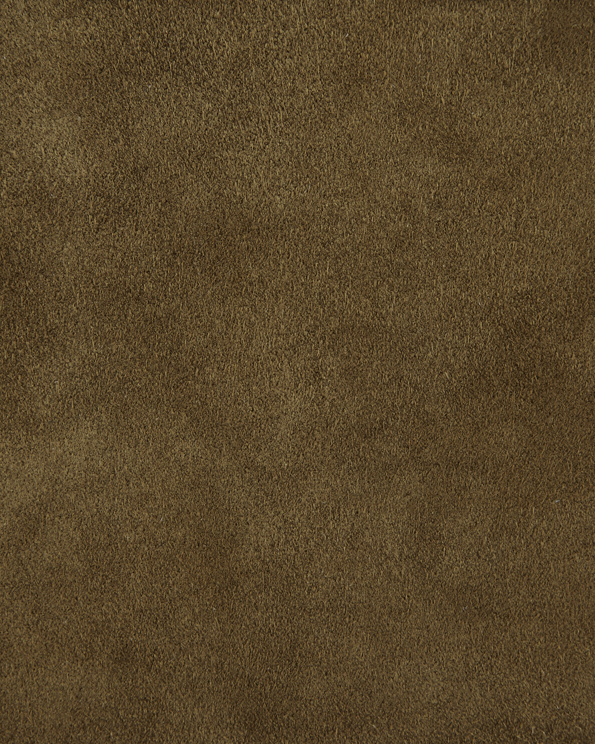 Close-up of a textured brown suede surface showing soft, slightly uneven fibers in natural lighting