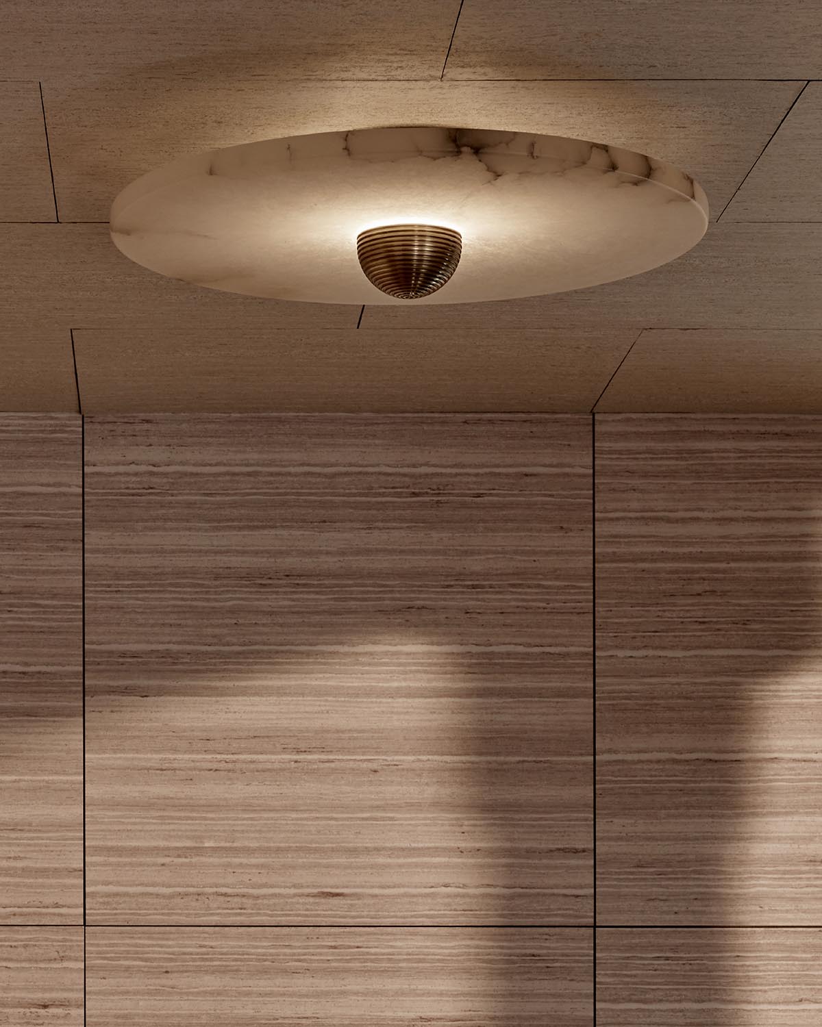 Circular marble ceiling light fixture with dark ribbed center against a wood-paneled ceiling and wall background