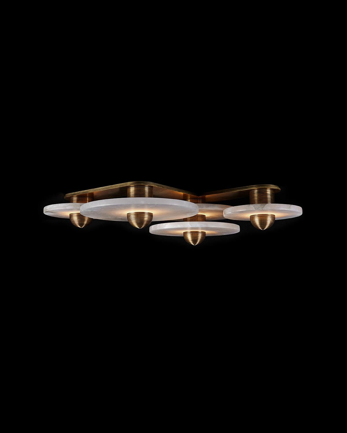Modern ceiling light fixture with four frosted glass discs and brass accents against black background