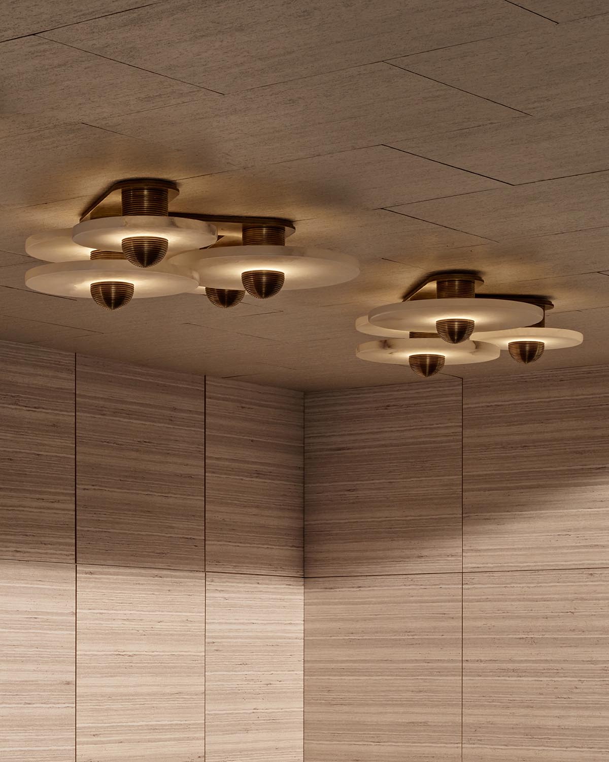 Cluster of modern ceiling lights with circular frosted glass shades and brass fixtures in a wood-paneled room ceiling