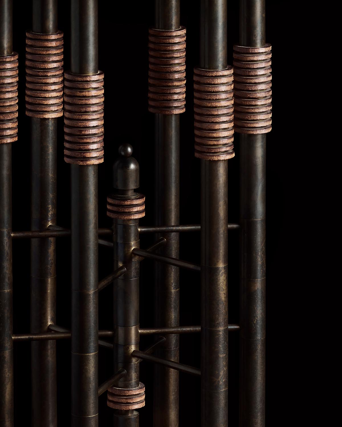 Close-up view of dark metal rods with rust-colored coil accents arranged vertically against a black background